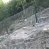 Laying rock-containing nets and barriers and rock stabilisation.