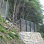 Rock-containing structures with HEA profiles on a concrete-reinforced, stone block wall.